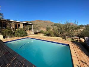 a large blue swimming pool in a yard at Sani Lodge & Cottages in Sani Pass