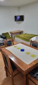 a table and chairs with a table and a bed at Apartman Boba in Ruma