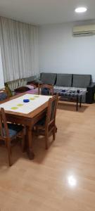 una stanza con un tavolo, sedie e un divano di Apartman Boba a Ruma