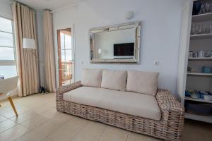 ein Korbsofa im Wohnzimmer mit Spiegel in der Unterkunft Casa Storm in Costa Calma
