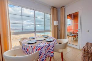 comedor con mesa, sillas y ventana en Casa Storm en Costa Calma