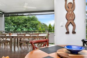 jadalnia ze stołem i krzesłami oraz dużym oknem w obiekcie Modern meets Tropical in this Free-standing Home w mieście Cairns North