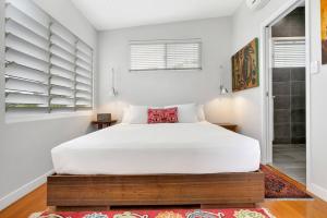 sypialnia z dużym łóżkiem i oknem w obiekcie Modern meets Tropical in this Free-standing Home w mieście Cairns North