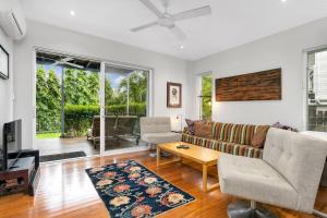 a living room with a couch and a table at Modern meets Tropical in this Free-standing Home in Cairns North