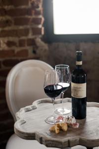 a bottle of wine and a glass on a wooden table at Agriturismo Ma Che Bel Castello in Mombaruzzo