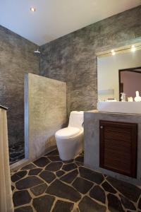 een badkamer met een toilet, een wastafel en een spiegel bij Lunar Villas Koh Tao - Luxury Private Pool Villas in Ko Tao