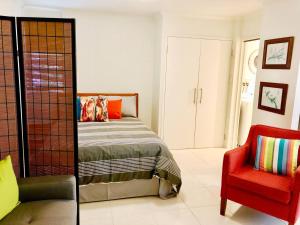sypialnia z łóżkiem i czerwonym krzesłem w obiekcie Coastal Living near Shops and Botanical Gardens w mieście Edge Hill
