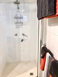 W łazience znajduje się prysznic ze szklanymi drzwiami. w obiekcie Coastal Living near Shops and Botanical Gardens w mieście Edge Hill