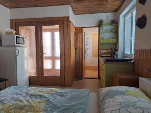 a kitchen with a bed and a refrigerator in a room at Jiřinka in Vracov