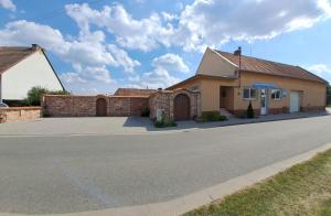 a house with a brick wall and a street at Jiřinka in Vracov