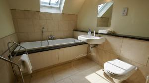 a bathroom with a tub and a toilet and a sink at Fire Station Cottage in Comrie +20 photos