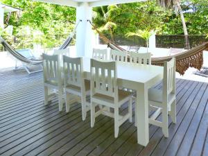 a white table and chairs on a deck at PIPA VILLA CAFE VERDE in Pipa