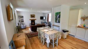 a kitchen and living room with a table and chairs at Edinample Lodge in Lochearnhead