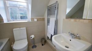 a bathroom with a toilet and a sink and a window at Edinample Lodge in Lochearnhead +17 photos