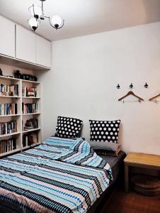 Books&Bed Close to the Lake في هانغتشو: غرفة نوم مع سرير ورف كتاب