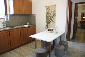 a kitchen with a white table and stools at PLATANOFYLLA Studios & Apartments in Kala Nera