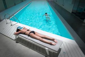 a woman in a bikini laying in a swimming pool at Fedra Boutique Apartments in Hersonissos