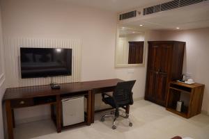 a room with a desk with a television and a chair at The Shanti A Boutique Hotel in Jodhpur