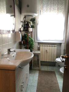 ein Bad mit einem Waschbecken, einem WC und einem Fenster in der Unterkunft Venice Treviso Airport Bed in Treviso