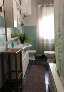 a bathroom with a sink and a toilet and a window at Venice Treviso Airport Bed in Treviso