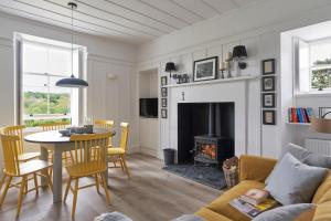 a living room with a table and a fireplace at Achnahatnich House in Aviemore