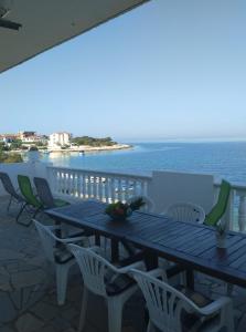 einen Holztisch und Stühle auf einem Balkon mit Meerblick in der Unterkunft Kanica seaside apartment Roko 10 m from sea in Sevid
