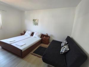 ein kleines Schlafzimmer mit einem Bett und einer Couch in der Unterkunft Kanica seaside apartment Roko 10 m from sea in Sevid