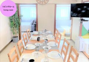 une salle à manger avec une table, des chaises et une horloge dans l'établissement くるみん-Kurumin501-, à Kurume