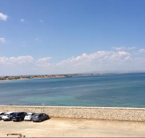 a group of cars parked next to the water at Sea House in Marzamemi