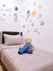 a teddy bear sitting on a bed in a bedroom at Hanns&FreeWIFI&Washer+Pool@SunshineComfortHMStay3 in Sibu