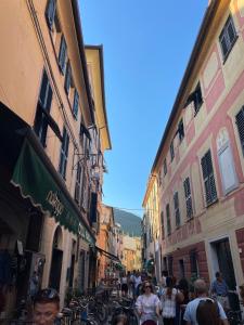 een groep mensen die door een straat met gebouwen loopt bij I Delfini in Levanto