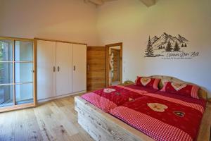 a bedroom with a large bed with red comforter at S´Milchkännla 