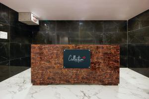 un vestíbulo de un hotel con un cartel en un mostrador de mármol en Super Capital O 65104 Che Sigma Hotel, en Surūrnagar