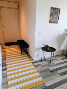 - un couloir avec une table, une porte et un tapis rayé dans l'établissement Valoisa yksiö parvekkeella, à Raisio