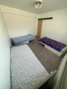 a small room with two beds in it at Bel appartement cosy très calme avec parking privé in Templemars