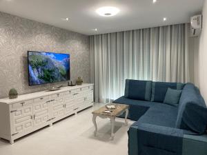 un soggiorno con divano blu e TV a schermo piatto di La fuente a Gandía