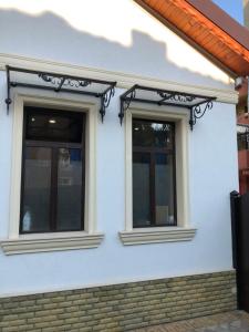 two windows on the side of a white house at White House in Pleven