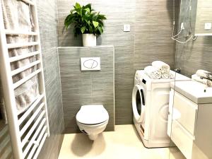 a bathroom with a toilet and a plant on the wall at Nick's place-brandnew, central and quiet apt by Margit bridge in Budapest