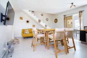 cocina y comedor con mesa de madera y sillas en Villa des Pentas – Chaleureuse Villa moderne avec piscine, en Baie-Mahault