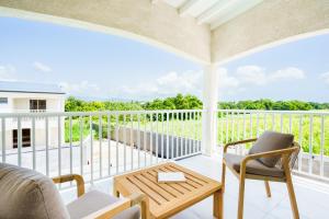 porche con sofá, sillas y mesa en Villa des Pentas – Chaleureuse Villa moderne avec piscine, en Baie-Mahault