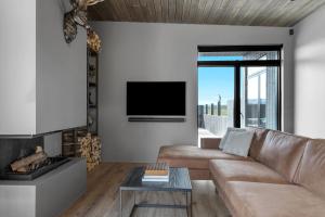 un soggiorno con divano e TV di Luxurious 4BR Summerhouse with Hot Tub and Sauna a Selfoss