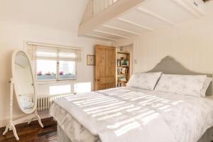 a bedroom with a large white bed and a window at Beautiful little Townhouse situated in Brighton's Regency Conservation Area in Brighton & Hove