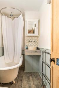 La salle de bains est pourvue d'une baignoire et d'un rideau de douche. dans l'établissement Beautiful little Townhouse situated in Brighton's Regency Conservation Area, à Brighton et Hove