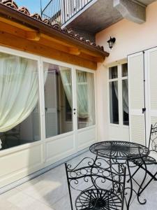 patio con mesa y sillas en el balcón en Casa Marchisio, en Canale
