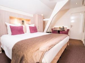 - une chambre avec un grand lit et des oreillers roses dans l'établissement De Twee Linden, à Beneden-Leeuwen