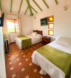 a bedroom with two beds and a window at Ecohotel La Casona Pereira in Pereira