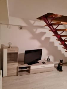 a living room with a tv and a staircase at Zur Sonnenblume 