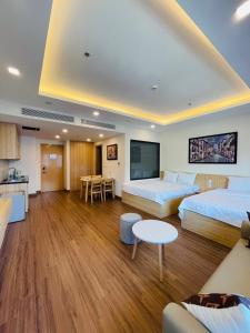 ein Hotelzimmer mit 2 Betten und einem Wohnzimmer in der Unterkunft FLC Apartment Beach Quy Nhơn in Quy Nhon