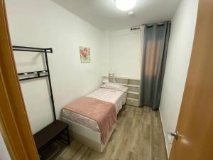 um pequeno quarto com uma cama e uma secretária em Puerto Playa Oceanografico Yulia em Valência