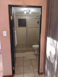 a bathroom with a shower and a toilet at Kwena Maribane Lodge in Erasmus